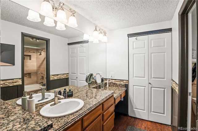 943 S Fairplay St, Aurora, CO 80012 - bathroom featuring vanity, wood finished floors, a closet, a textured ceiling, and bathing tub / shower combination
