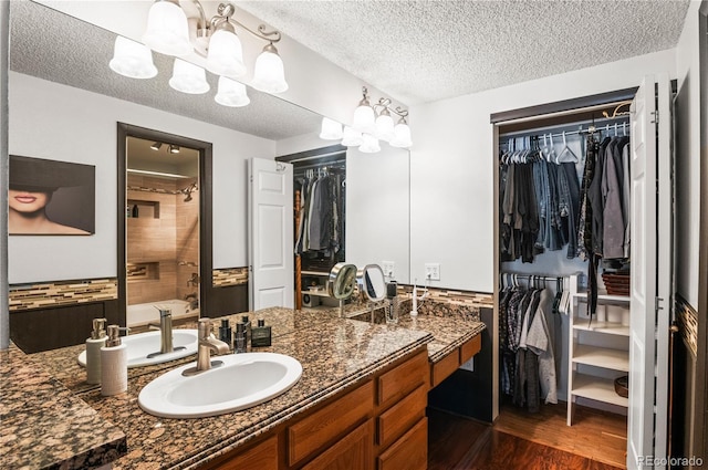 943 S Fairplay St, Aurora, CO 80012 - full bath with a spacious closet, vanity, a textured ceiling, wood finished floors, and a chandelier