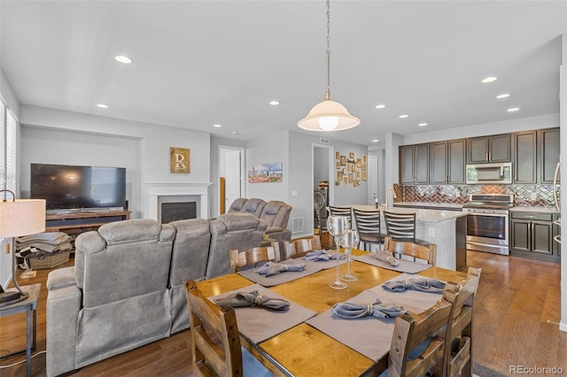 15895 Columbine St, Thornton, CO 80602 - dining area featuring dark wood-type flooring, recessed lighting, and a fireplace