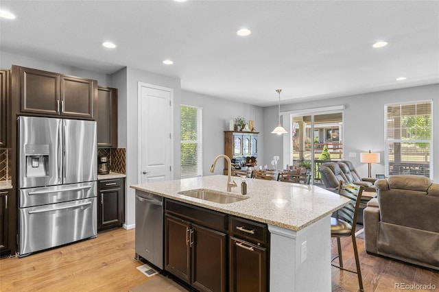 15895 Columbine St, Thornton, CO 80602 - kitchen featuring appliances with stainless steel finishes, open floor plan, light wood-type flooring, a kitchen breakfast bar, and recessed lighting