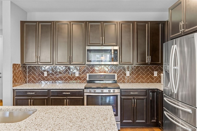 15895 Columbine St, Thornton, CO 80602 - kitchen with stainless steel appliances, light stone counters, dark brown cabinetry, and backsplash