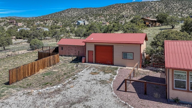 10199 W Cheyenne Cir, Salida, CO 81201 - view of front of house with a mountain view, metal roof, driveway, and an outbuilding