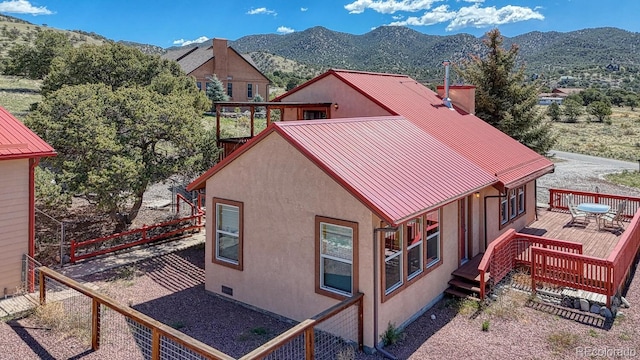 10199 W Cheyenne Cir, Salida, CO 81201 - back of house featuring stucco siding, a deck with mountain view, a fenced backyard, and a standing seam roof