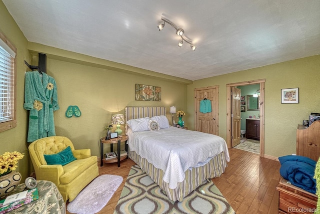 10199 W Cheyenne Cir, Salida, CO 81201 - bedroom with hardwood / wood-style flooring, connected bathroom, and baseboards