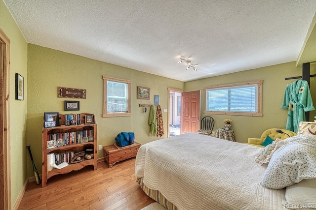 10199 W Cheyenne Cir, Salida, CO 81201 - bedroom with a textured wall, hardwood / wood-style floors, baseboards, and a textured ceiling