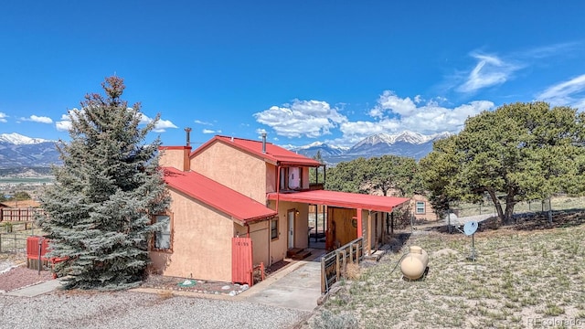 10199 W Cheyenne Cir, Salida, CO 81201 - view of front of home with a mountain view, stucco siding, metal roof, and covered porch