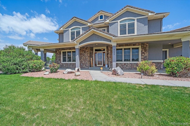 8655 E 130th Ave, Thornton, CO 80602 - view of front of property featuring stone siding, a porch, a front lawn, and stucco siding