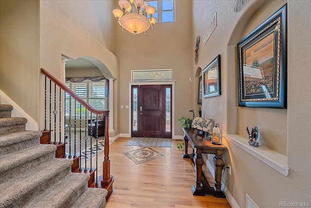 8655 E 130th Ave, Thornton, CO 80602 - foyer featuring stairway, wood finished floors, arched walkways, baseboards, and a towering ceiling