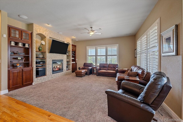 8655 E 130th Ave, Thornton, CO 80602 - carpeted living room featuring ceiling fan, a fireplace, built in features, and baseboards