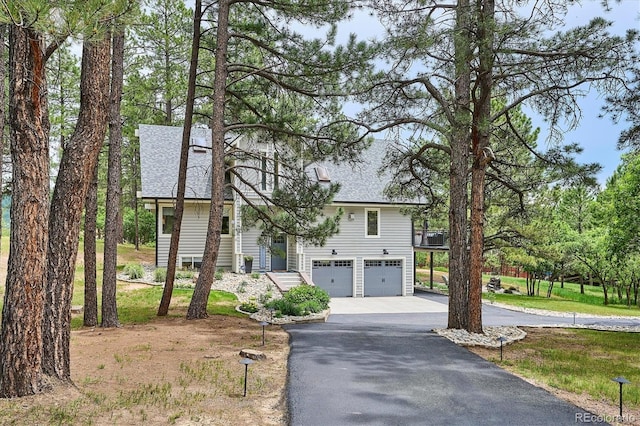 7312 Marshall Rd, Larkspur, CO 80118 - view of front of home featuring driveway, an attached garage, and roof with shingles