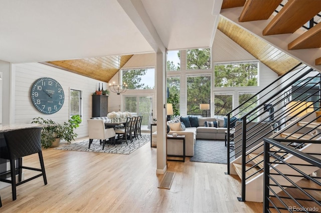 7312 Marshall Rd, Larkspur, CO 80118 - living area featuring high vaulted ceiling, plenty of natural light, light wood-type flooring, stairs, and a chandelier