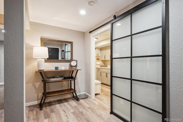 7312 Marshall Rd, Larkspur, CO 80118 - hallway with light wood-style flooring, a barn door, and recessed lighting