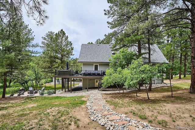 7312 Marshall Rd, Larkspur, CO 80118 - rear view of property featuring a deck, a fire pit, roof with shingles, and a patio