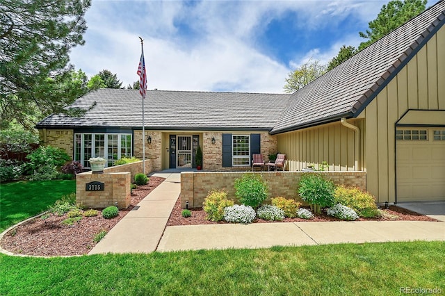 view of front facade featuring board and batten siding, brick siding, and an attached garage