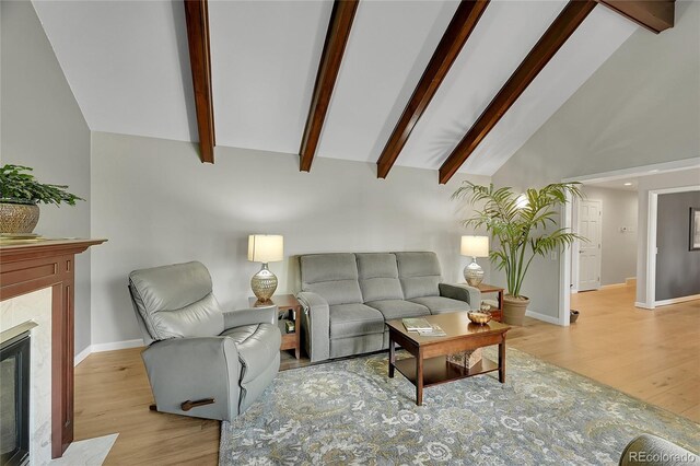 living room featuring high vaulted ceiling, light wood-type flooring, baseboards, beamed ceiling, and a premium fireplace