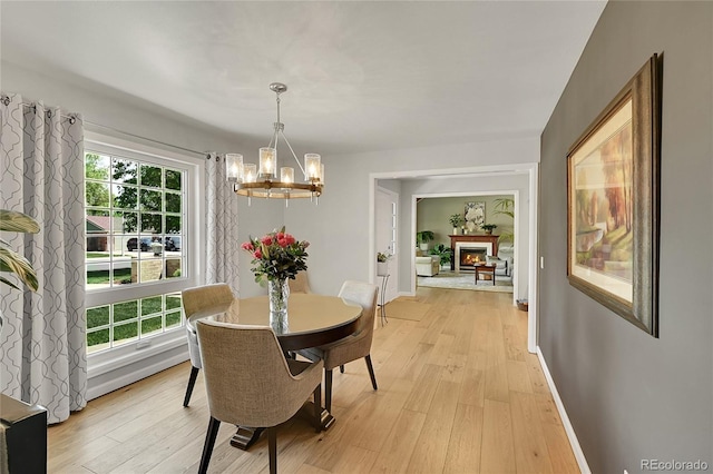 dining space featuring a chandelier, light wood finished floors, and healthy amount of natural light