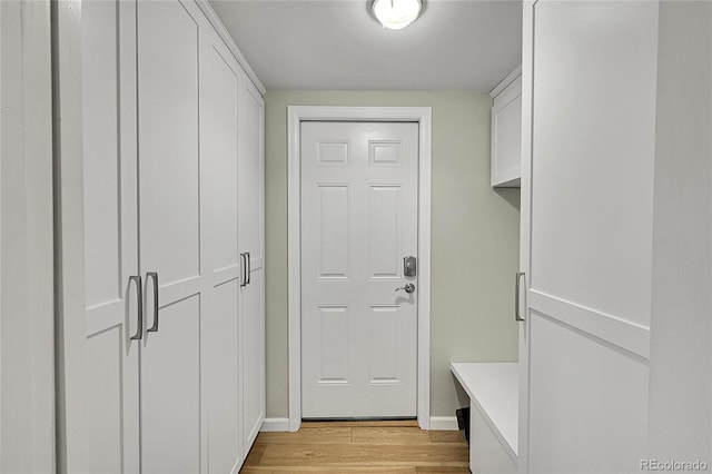 mudroom featuring light wood-style flooring and baseboards