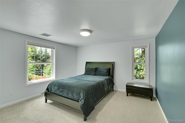 bedroom with baseboards, multiple windows, and carpet floors