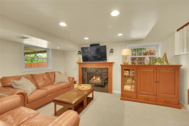 living room with light colored carpet, recessed lighting, a tiled fireplace, healthy amount of natural light, and baseboards