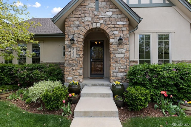 652 Ulster Way, Denver, CO 80230 - entrance to property featuring stucco siding, stone siding, and a shingled roof