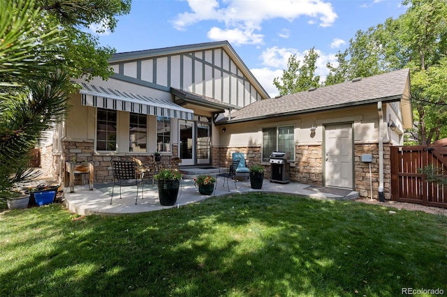 652 Ulster Way, Denver, CO 80230 - back of house featuring stone siding, a lawn, and a patio area