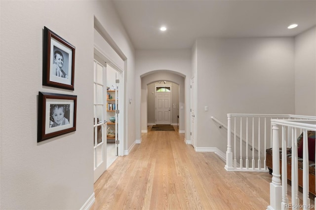 652 Ulster Way, Denver, CO 80230 - hallway with arched walkways, light wood finished floors, recessed lighting, an upstairs landing, and baseboards