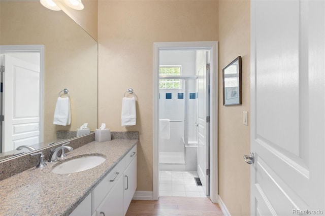 652 Ulster Way, Denver, CO 80230 - full bath featuring vanity, a stall shower, baseboards, and wood finished floors