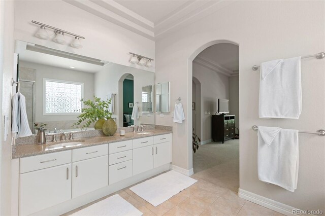 652 Ulster Way, Denver, CO 80230 - ensuite bathroom with double vanity, tile patterned flooring, ornamental molding, and baseboards