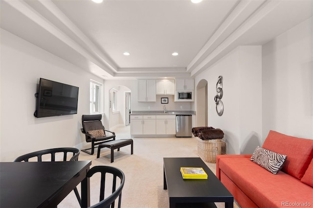 652 Ulster Way, Denver, CO 80230 - living room featuring arched walkways, a raised ceiling, recessed lighting, and light colored carpet