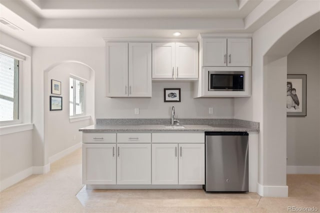 652 Ulster Way, Denver, CO 80230 - kitchen with stainless steel appliances, a sink, arched walkways, and baseboards
