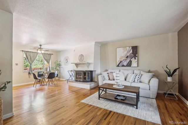 3871 W Saratoga Ave, Littleton, CO 80123 - living room with wood finished floors, ceiling fan, and a glass covered fireplace