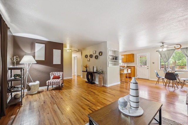 3871 W Saratoga Ave, Littleton, CO 80123 - living room with a ceiling fan, light wood-style floors, and a textured ceiling
