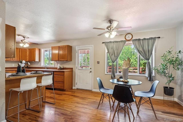 3871 W Saratoga Ave, Littleton, CO 80123 - dining area featuring a ceiling fan, light wood-style floors, and a textured ceiling
