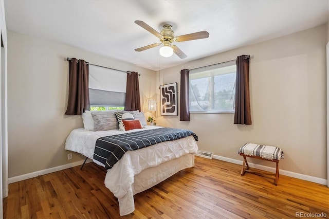 3871 W Saratoga Ave, Littleton, CO 80123 - bedroom with multiple windows, wood finished floors, and a ceiling fan