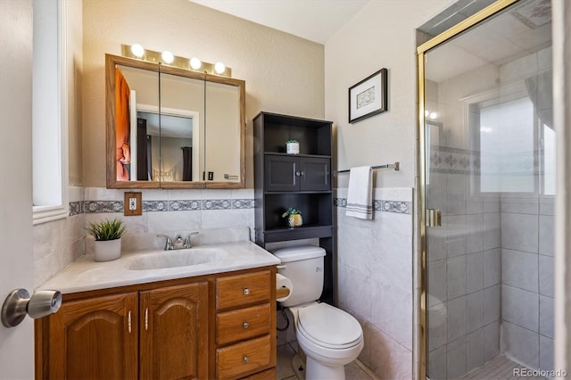 3871 W Saratoga Ave, Littleton, CO 80123 - full bathroom featuring tile walls, vanity, a stall shower, and a wainscoted wall