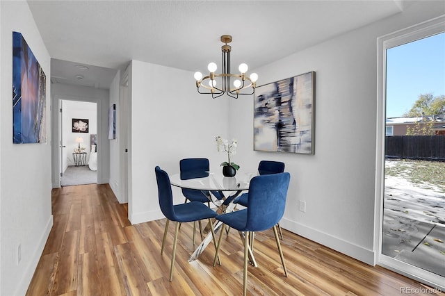 dining area featuring wood-type flooring and a notable chandelier