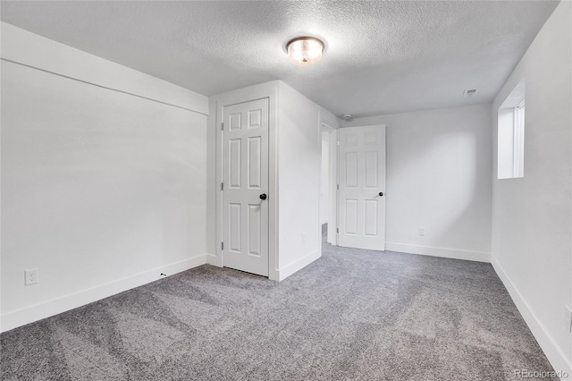 additional living space featuring carpet flooring and a textured ceiling