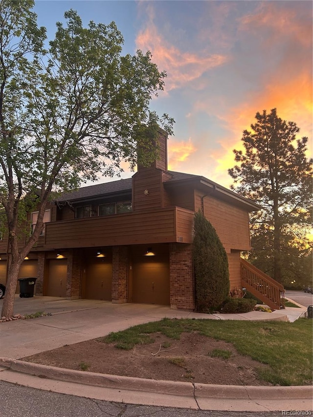5555 E Briarwood Ave Unit 706, Centennial, CO 80122 - view of front of home featuring concrete driveway, an attached garage, stairs, brick siding, and a chimney