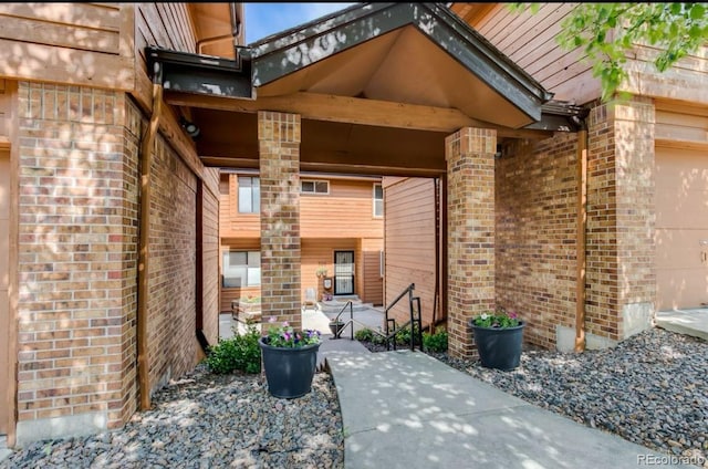5555 E Briarwood Ave Unit 706, Centennial, CO 80122 - doorway to property featuring brick siding and an attached garage