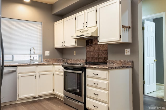 5555 E Briarwood Ave Unit 706, Centennial, CO 80122 - kitchen with under cabinet range hood, stainless steel appliances, a sink, dark wood-type flooring, and white cabinetry