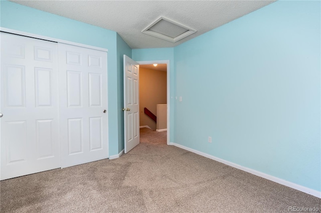 5555 E Briarwood Ave Unit 706, Centennial, CO 80122 - unfurnished bedroom featuring carpet floors, attic access, a closet, baseboards, and a textured ceiling