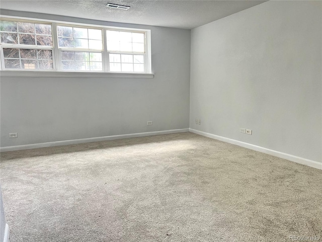 carpeted empty room featuring a textured ceiling