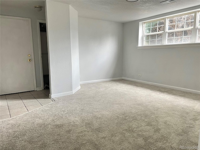 unfurnished room featuring light carpet and a textured ceiling