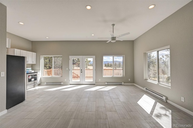 unfurnished living room with french doors, a wealth of natural light, and a baseboard heating unit