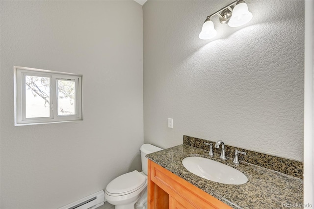 bathroom featuring vanity, toilet, and baseboard heating