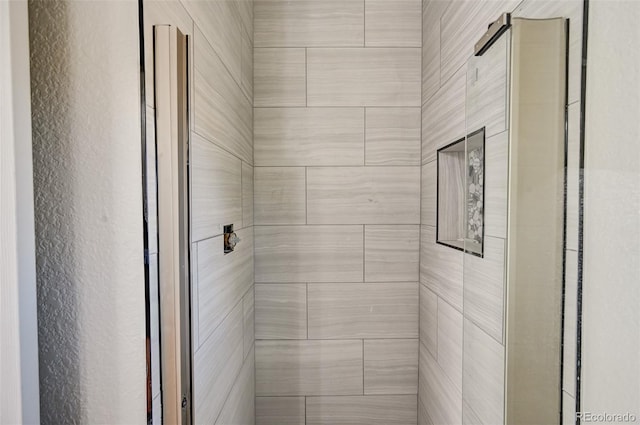 interior details featuring tiled shower