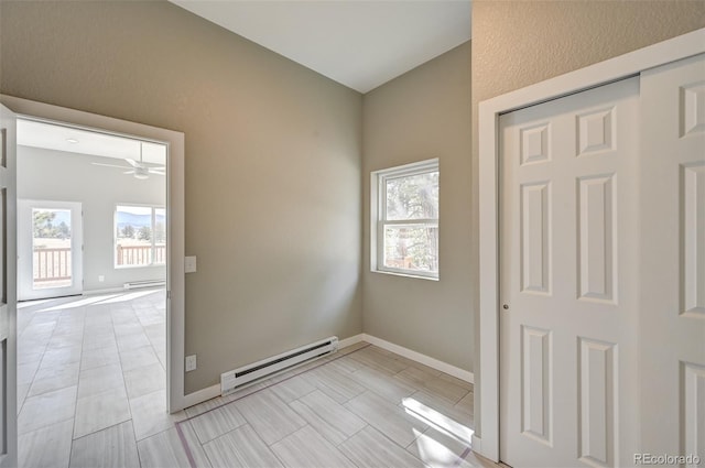 spare room featuring ceiling fan and a baseboard heating unit