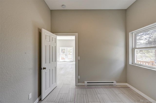 empty room with a baseboard radiator and a wealth of natural light