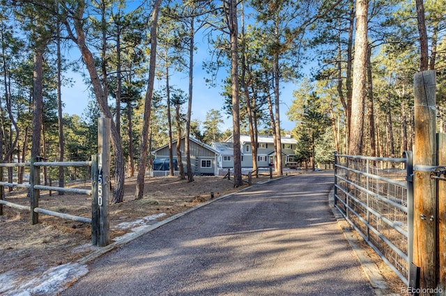 view of street featuring aphalt driveway and a gated entry