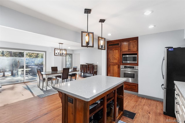 kitchen with recessed lighting, light wood-style flooring, pendant lighting, and stainless steel appliances